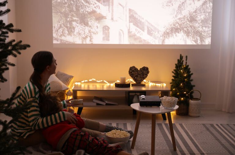 A woman watching a movie from a projector.