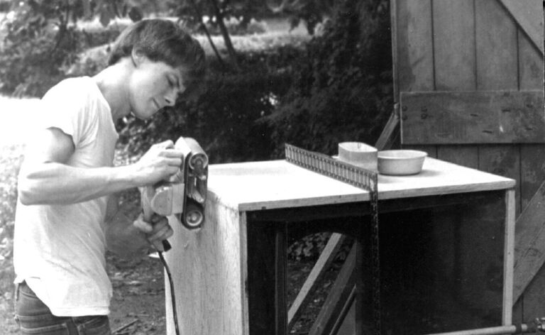 Man sanding homemade speaker cabinet Man sanding homemade speaker cabinet